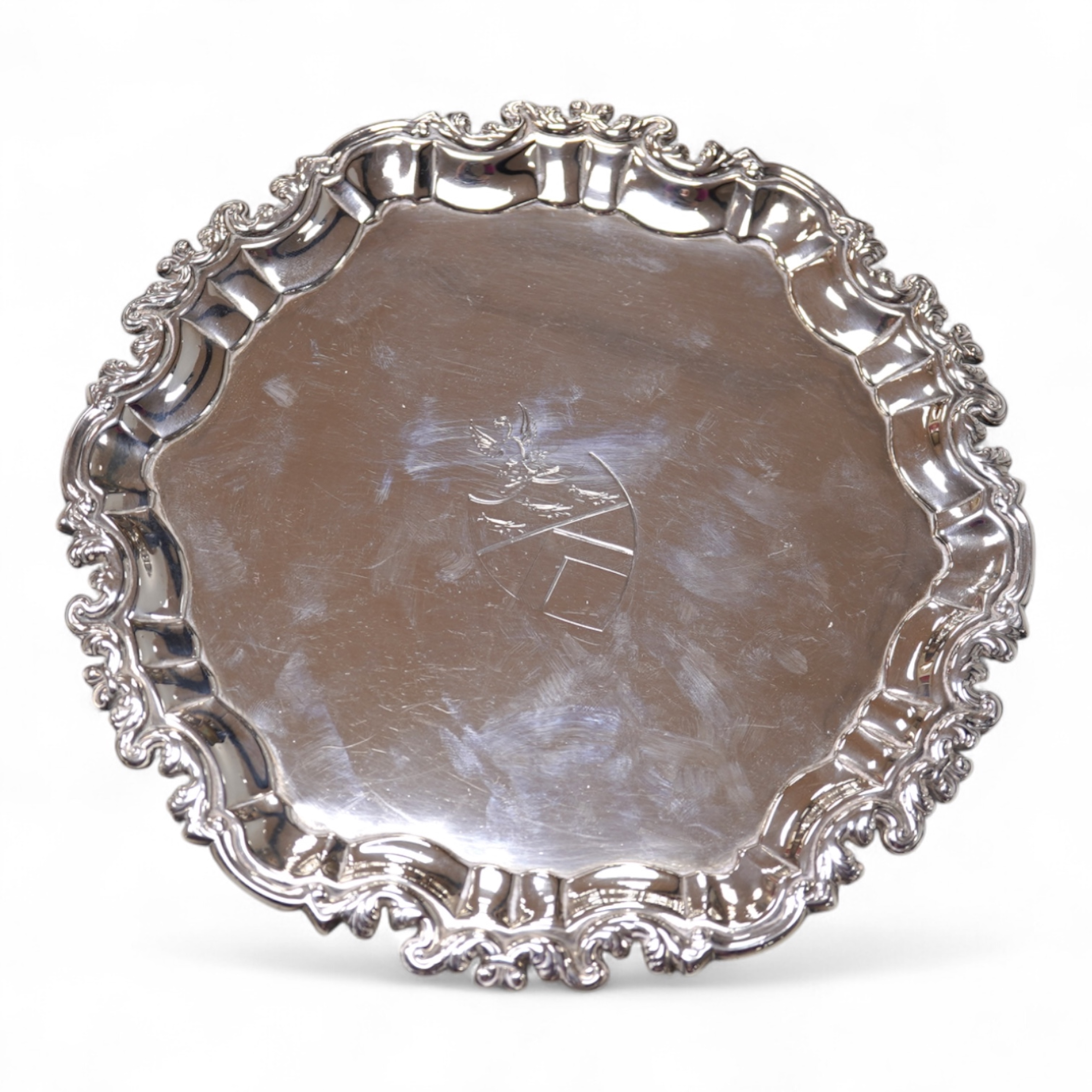 A George II silver card waiter, (with Howard Tripp crest?), of shaped circular form, on three scroll feet, maker's mark rubbed, London, 1740, 17.9cm, 9.4oz.